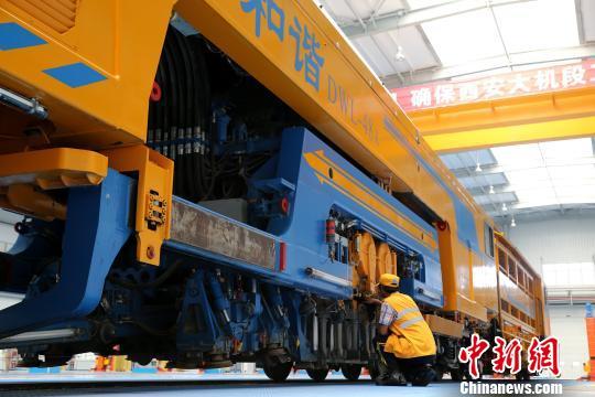 圖為工人正在清理大型養(yǎng)路機(jī)械?！堖h(yuǎn) 攝